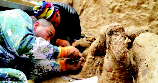 考古队员正在小心剥离陶俑上的泥土。